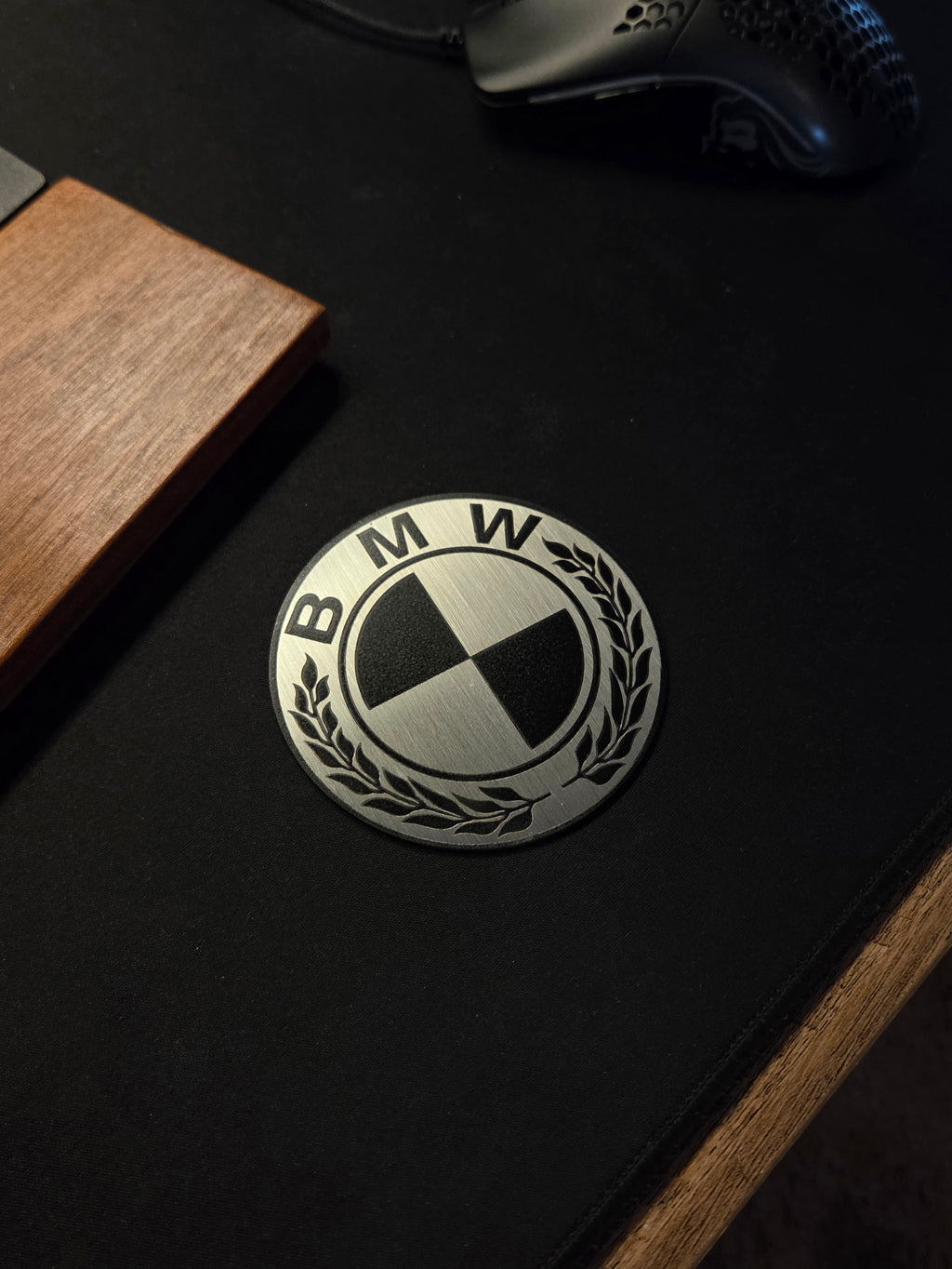 BMW logo on a black surface with wooden and metallic objects around